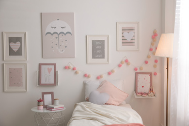 Stylish child's room interior with beautiful pictures and comfortable bed