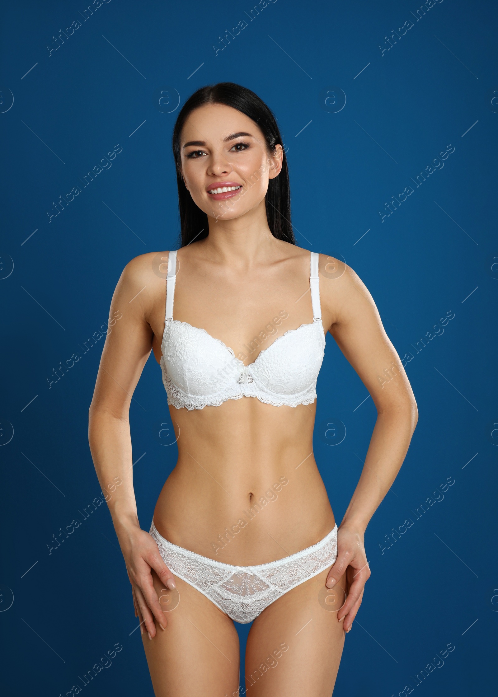 Photo of Beautiful young woman in white underwear on blue background