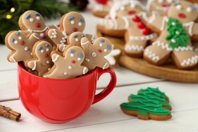 Photo of Delicious homemade Christmas cookies in cup on white wooden table. Space for text