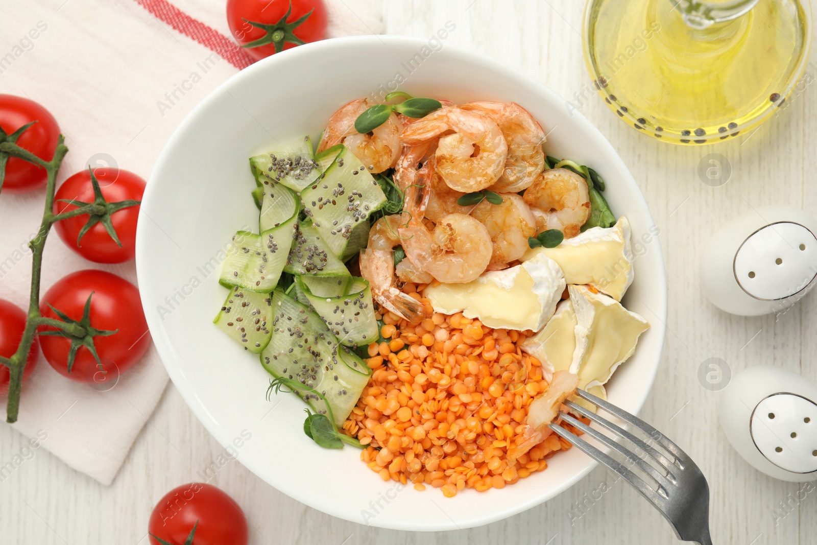 Photo of Delicious lentil bowl with shrimps, soft cheese and cucumber on white wooden table, flat lay