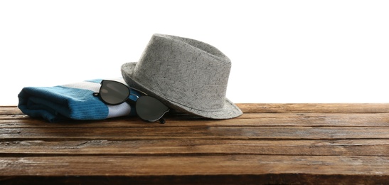 Photo of Hat, sunglasses and towel on wooden table, space for text. Beach accessories