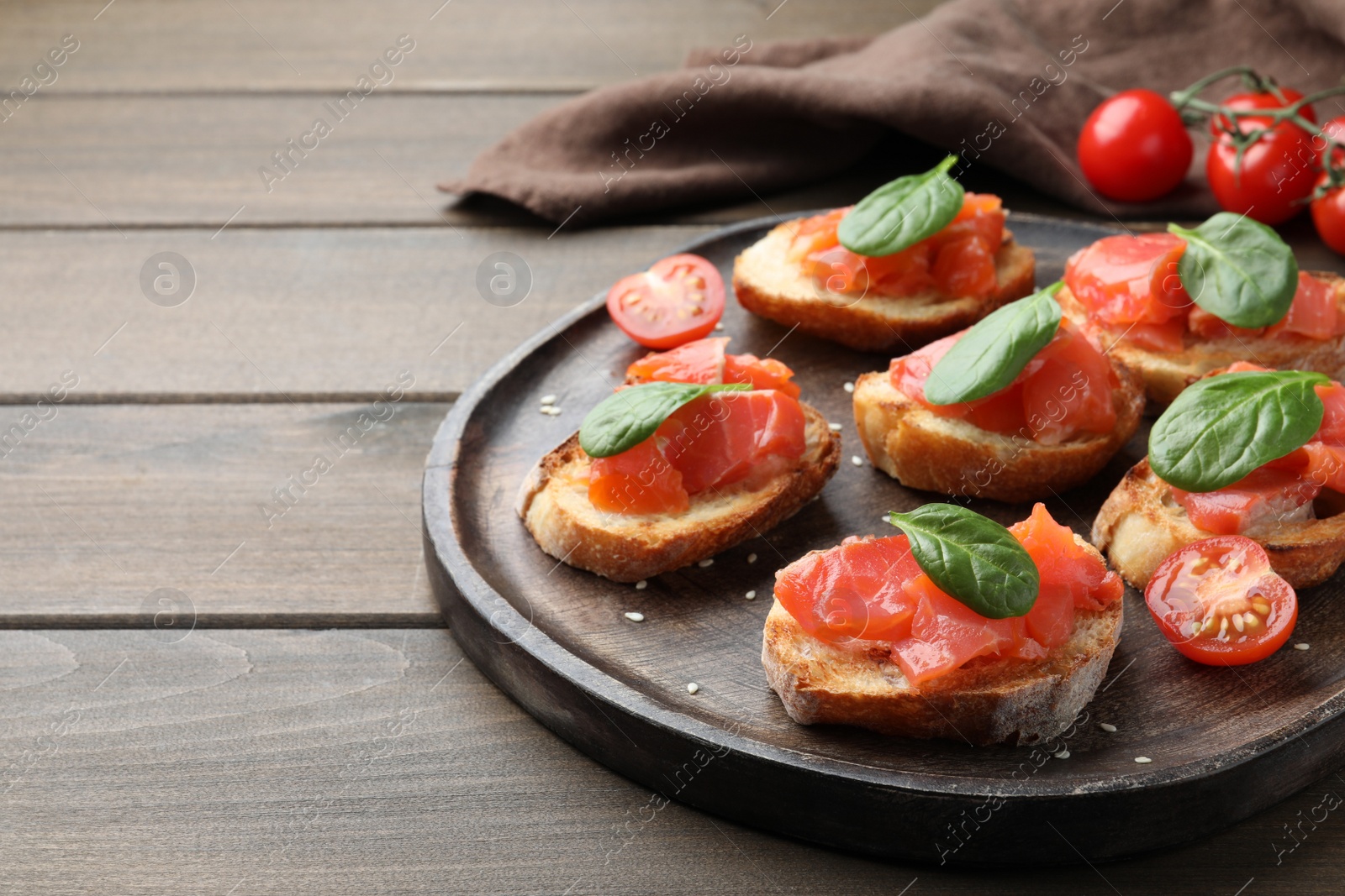 Photo of Delicious sandwiches with salmon and spinach on wooden table. Space for text