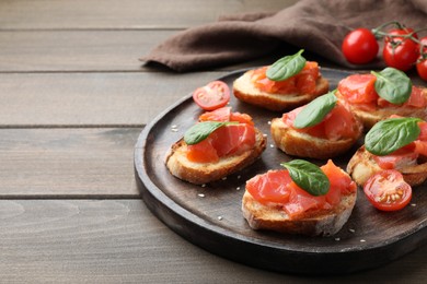 Photo of Delicious sandwiches with salmon and spinach on wooden table. Space for text