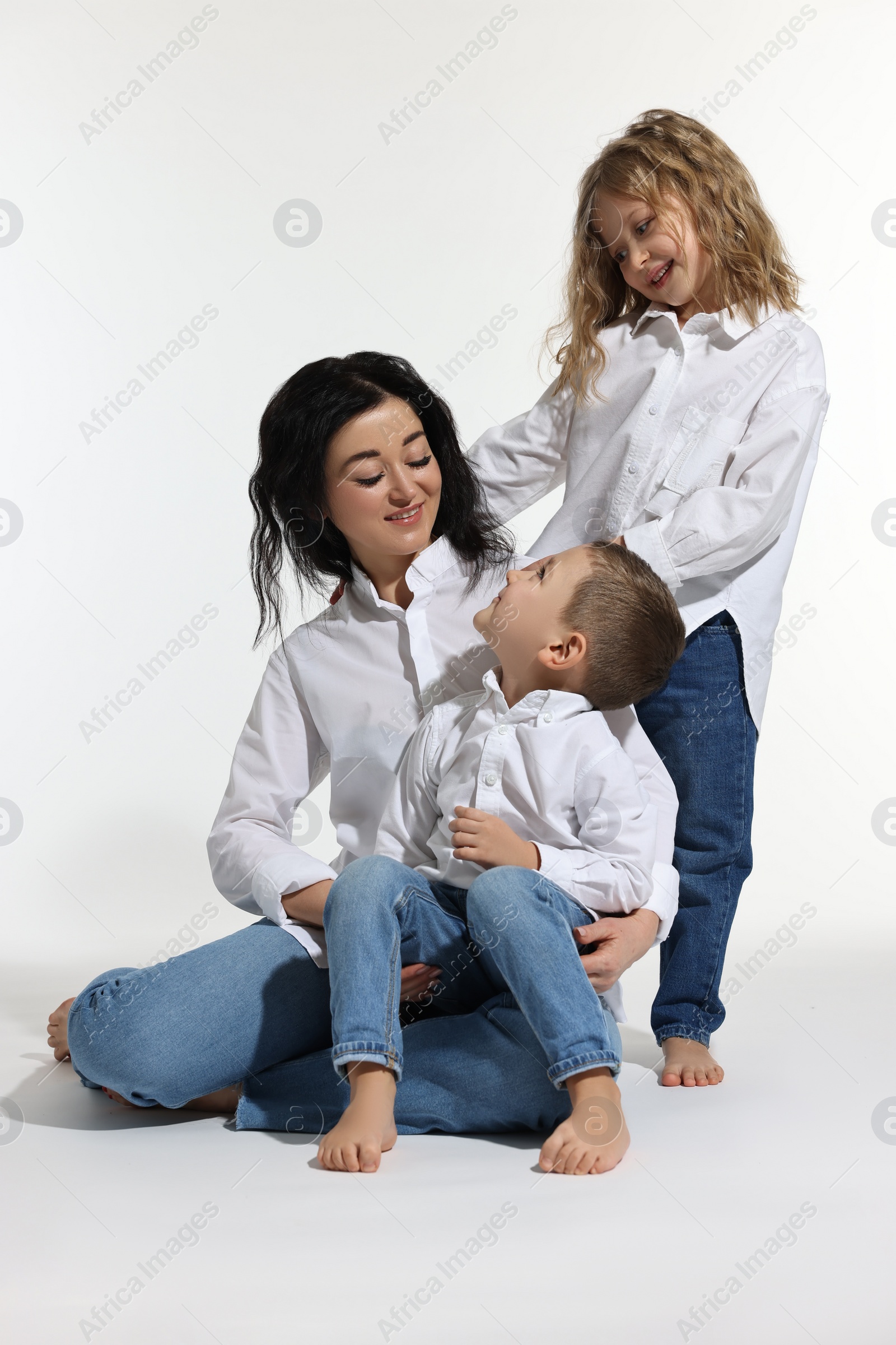 Photo of Little children with their mother on white background