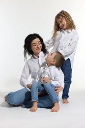 Photo of Little children with their mother on white background