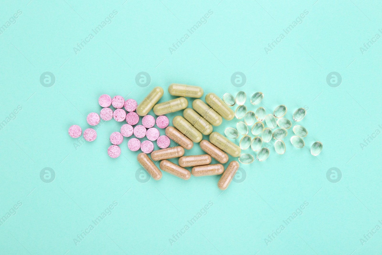 Photo of Many different vitamin pills on turquoise background, flat lay