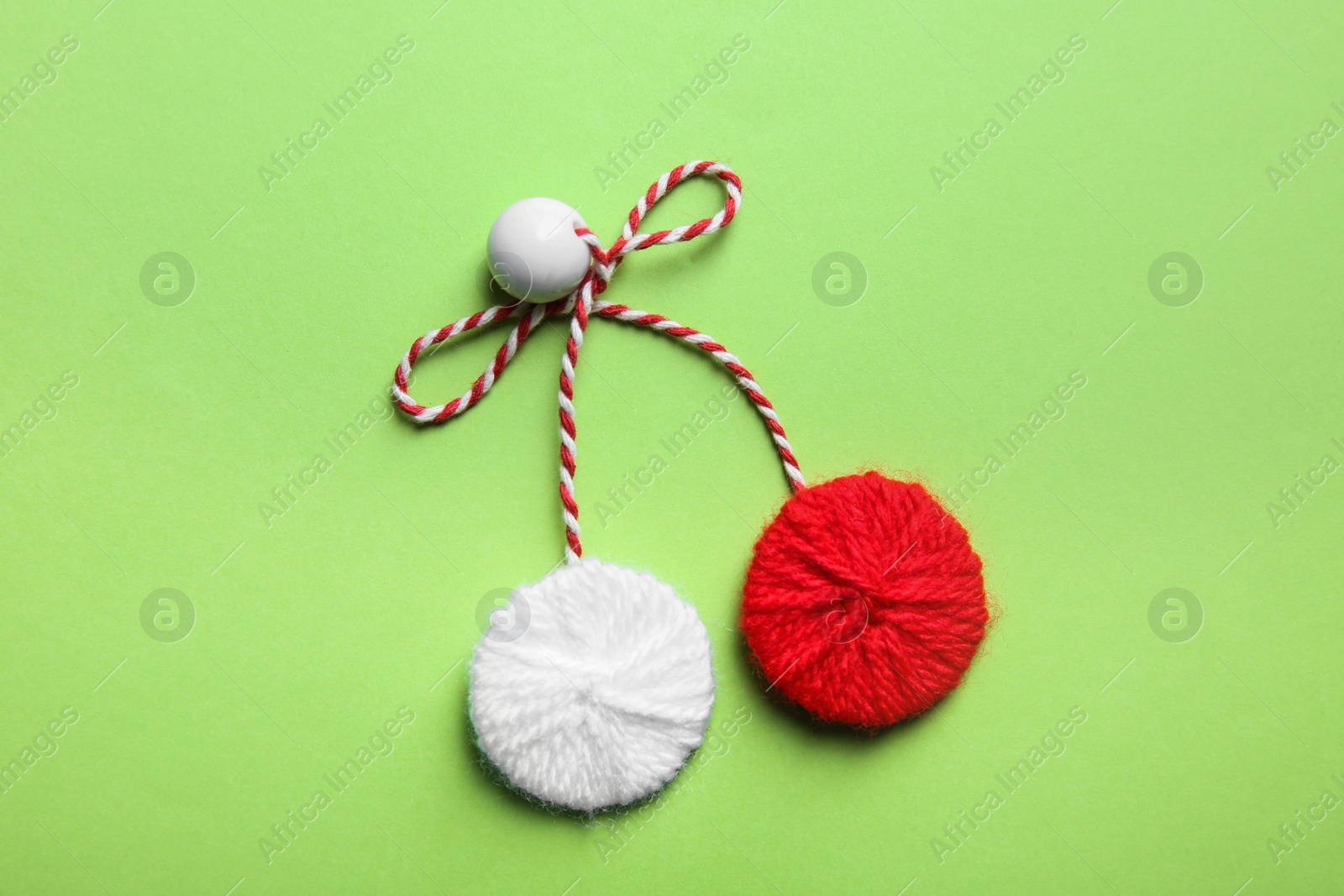 Photo of Traditional martisor on green background, top view. Beginning of spring celebration