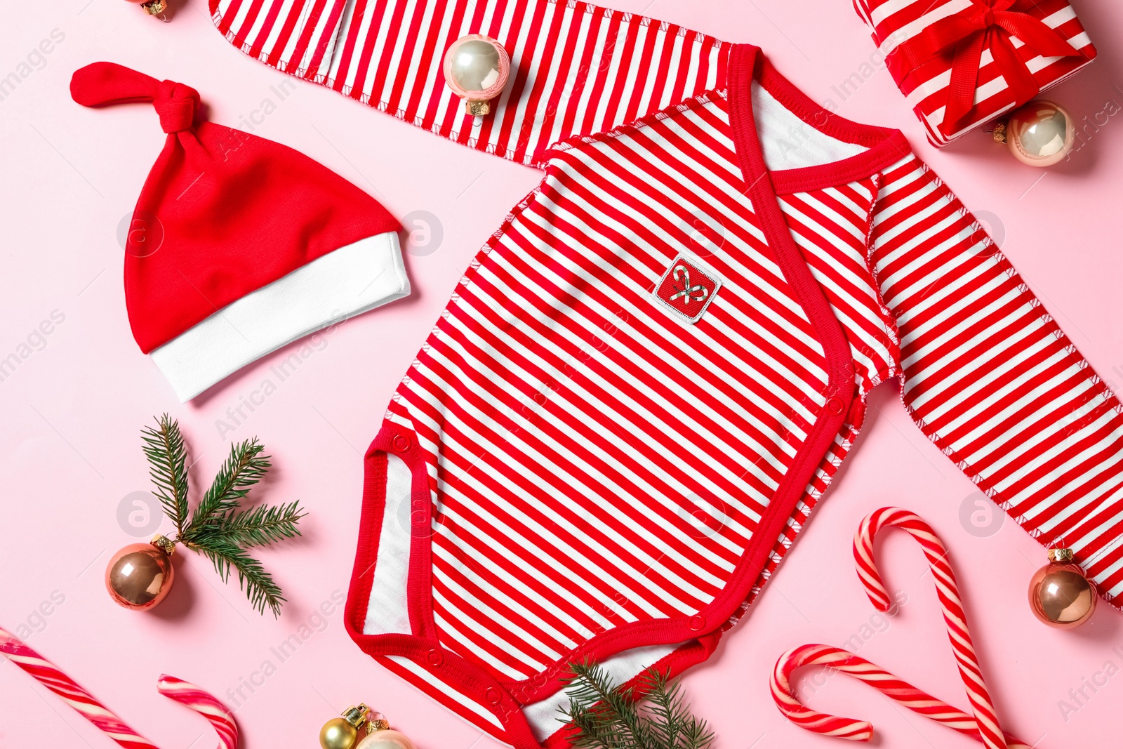 Photo of Flat lay composition with cute Christmas baby clothes on pink background