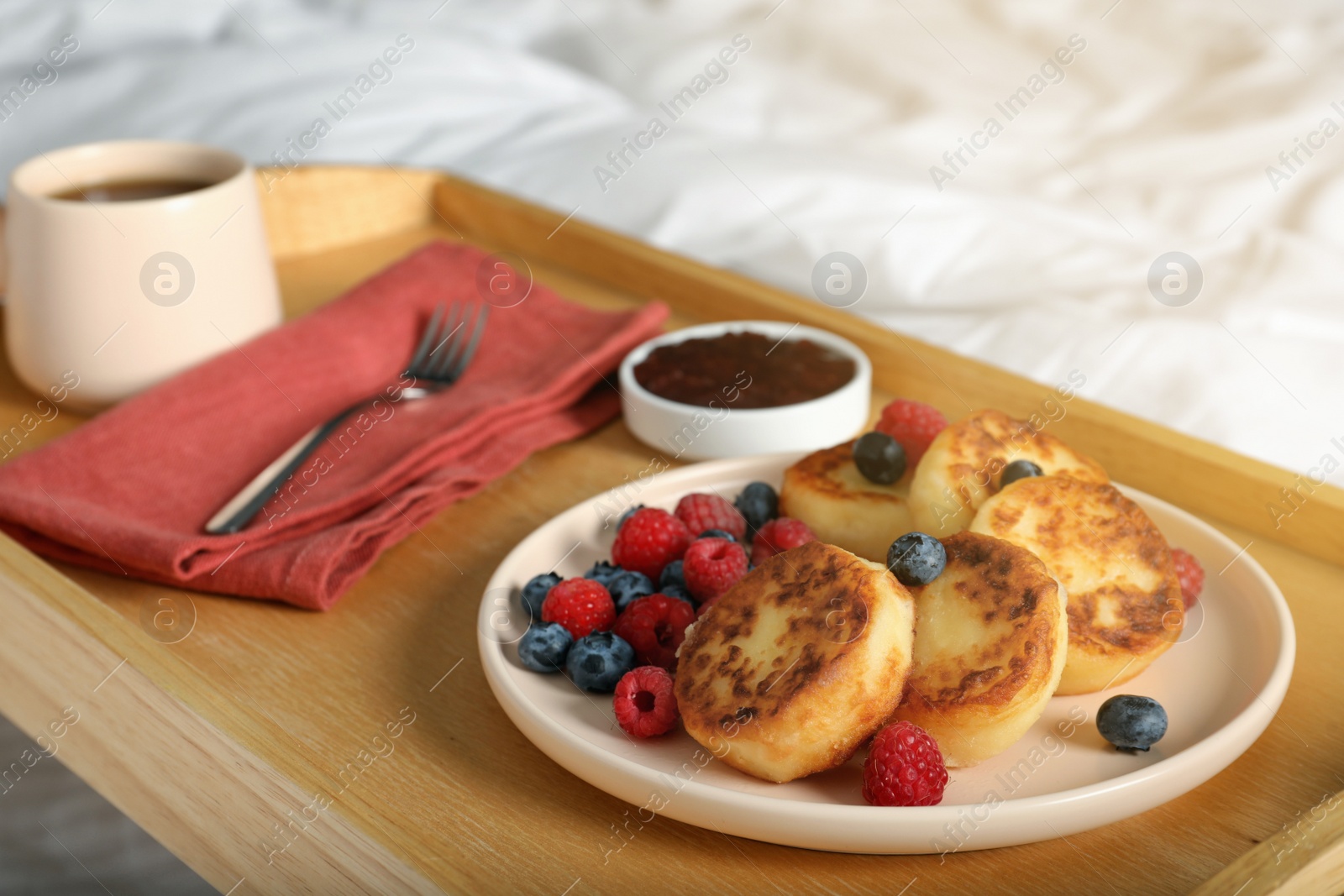 Photo of Delicious cottage cheese pancakes with fresh berries served on bed tray