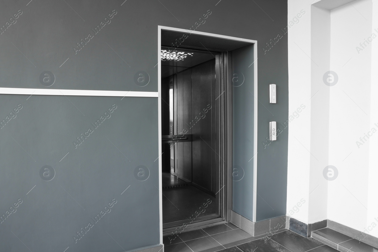 Photo of Open elevator`s cabin with big mirror in hall