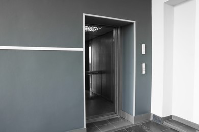 Photo of Open elevator`s cabin with big mirror in hall