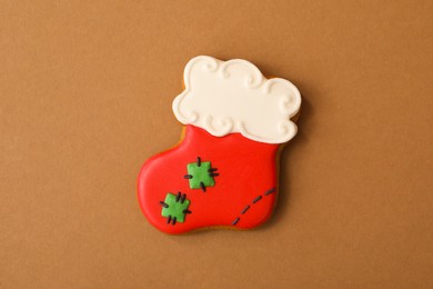 Christmas stocking shaped gingerbread cookie on brown background, top view