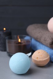 Beautiful composition with aromatic bath bombs on light grey table, closeup. Space for text