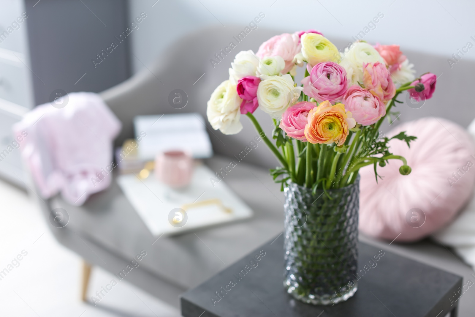 Photo of Bouquet of beautiful ranunculuses on table in living room. Space for text