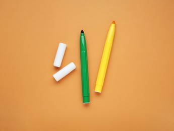 Green and yellow markers on light brown background, flat lay