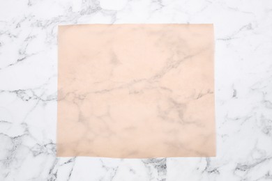 Photo of Sheet of baking paper on white marble table, top view