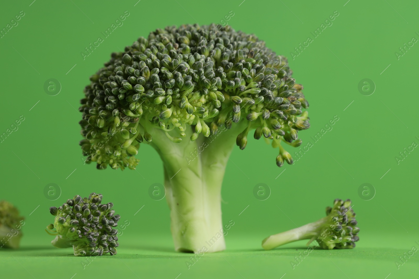 Photo of Fresh raw broccoli on light green background