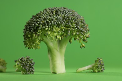 Fresh raw broccoli on light green background