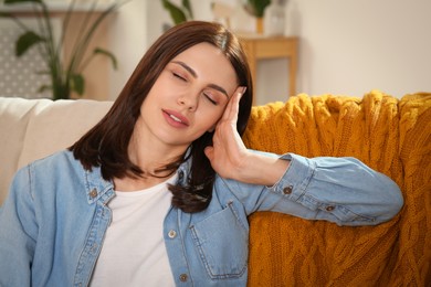 Photo of Young woman suffering from headache indoors. Hormonal disorders
