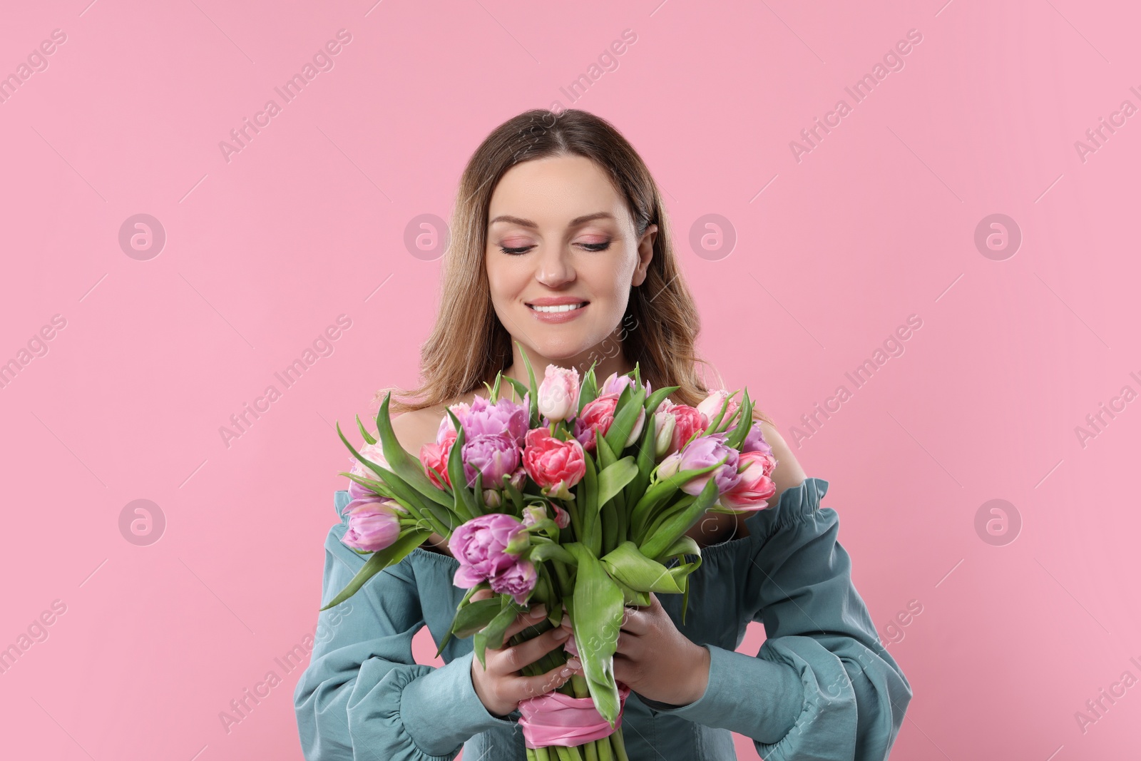 Photo of Happy young woman with bouquet of beautiful tulips on pink background