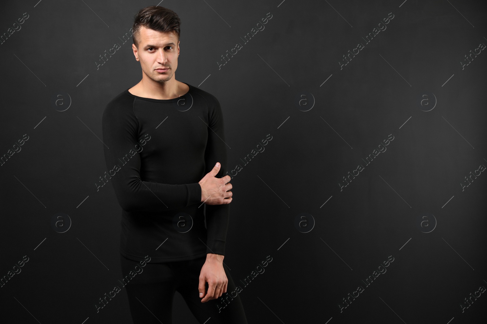 Photo of Man wearing thermal underwear on black background. Space for text