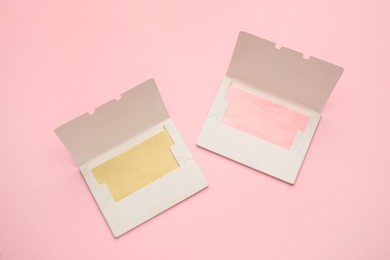 Photo of Facial oil blotting tissues on pink background, flat lay. Mattifying wipes