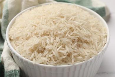 Photo of Raw basmati rice in bowl on table, closeup