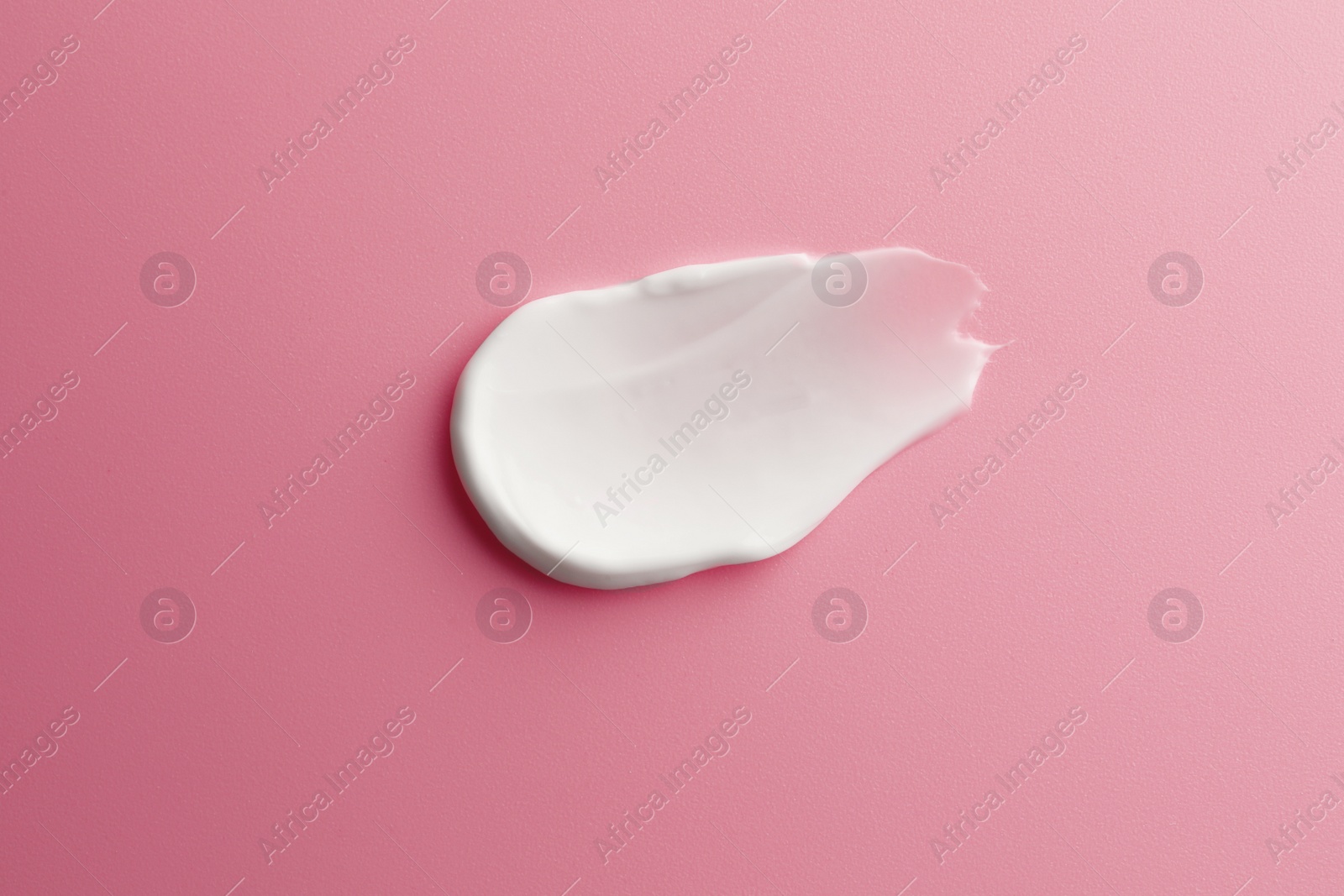 Photo of Sample facial cream on pink background, top view