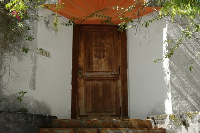 Photo of House entrance with old wooden door outdoors