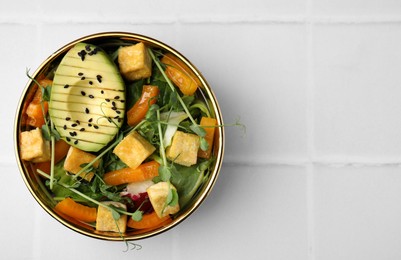 Photo of Delicious salad with tofu and vegetables on white tiled table, top view. Space for text