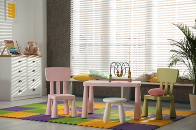 Stylish playroom interior with toys and modern furniture