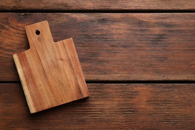 Photo of One new cutting board on wooden table, top view. Space for text