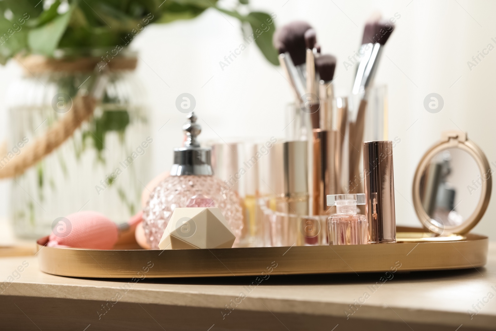 Photo of Tray with different makeup products and accessories on dressing table