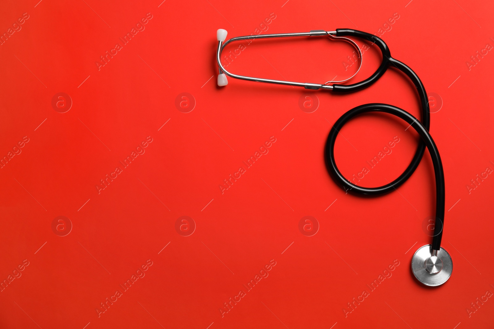 Photo of Stethoscope with space for text on color background, top view. Medical tool