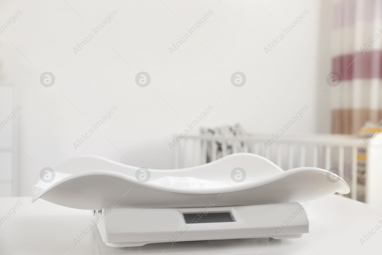 Photo of Modern digital baby scales on table in room. Space for text