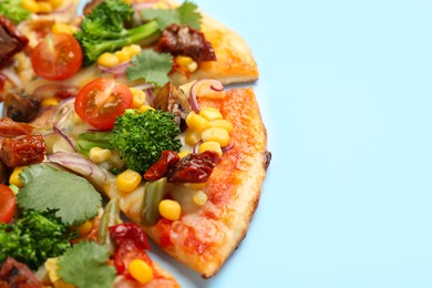 Photo of Delicious vegetarian pizza with mushrooms, vegetables and parsley on light blue background, closeup. Space for text