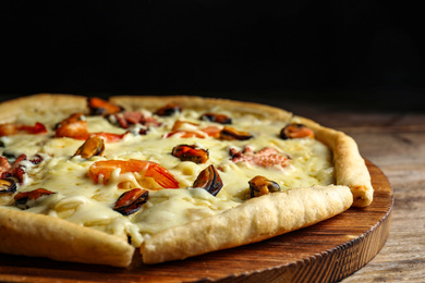 Delicious seafood pizza on wooden table, closeup
