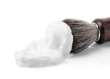 Photo of Shaving foam and brush on white background