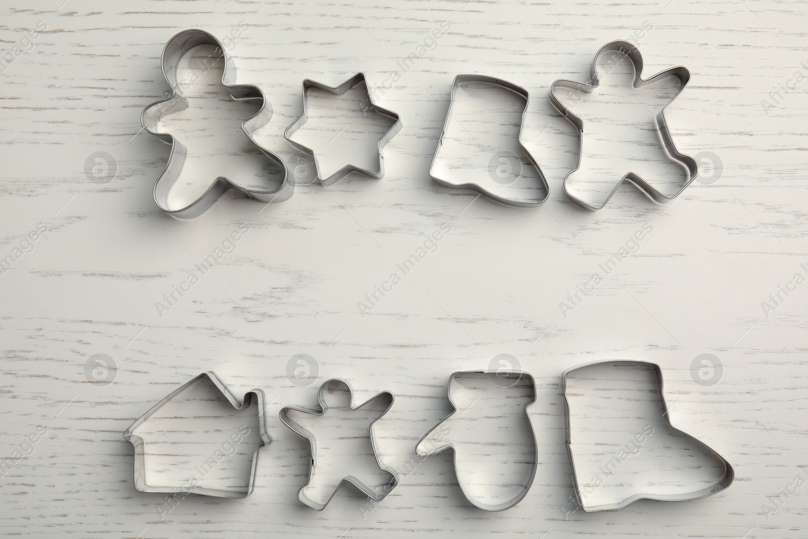 Photo of Different cookie cutters on white wooden table, flat lay. Space for text