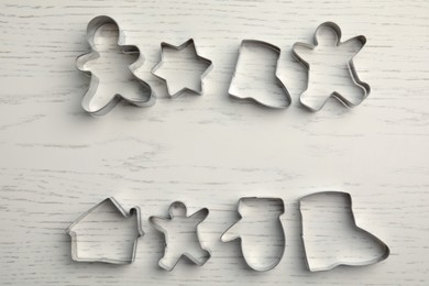 Photo of Different cookie cutters on white wooden table, flat lay. Space for text
