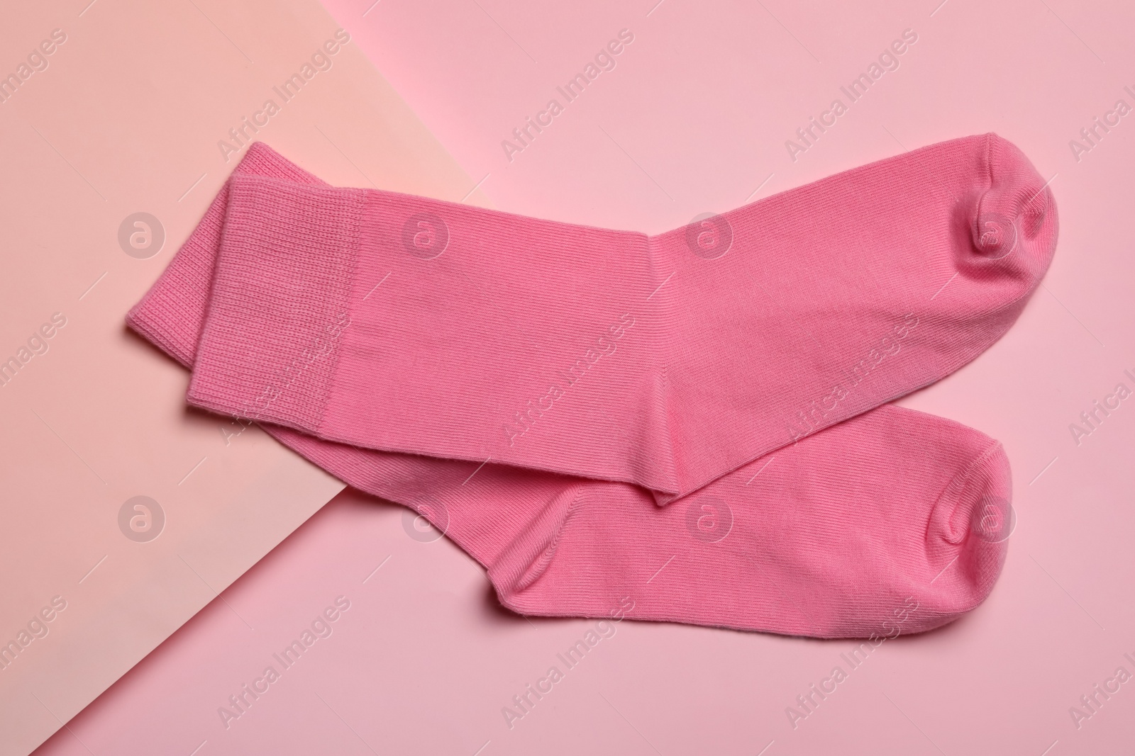 Photo of Pair of new socks on pink background, flat lay