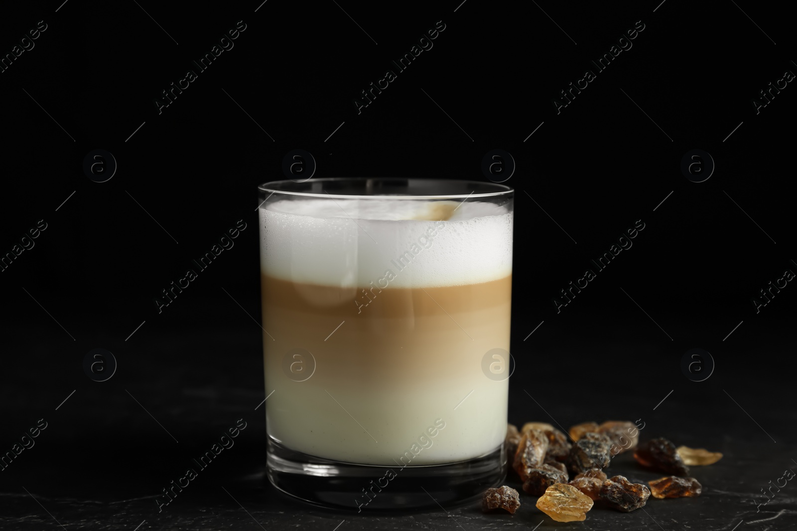 Photo of Delicious latte macchiato on table against black background