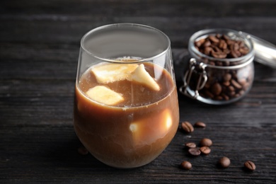 Photo of Coffee drink with milk ice cubes and beans on dark background