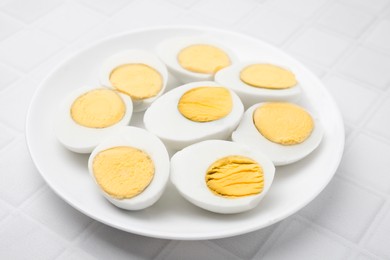 Photo of Fresh hard boiled eggs on white tiled table