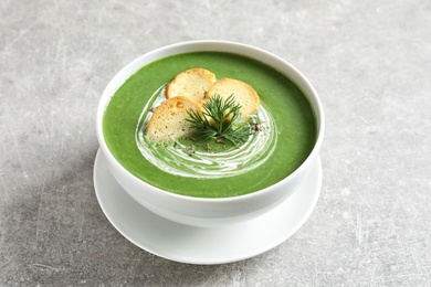 Photo of Fresh vegetable detox soup with croutons in dish on table