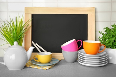 Photo of Set of dishware on table near chalkboard