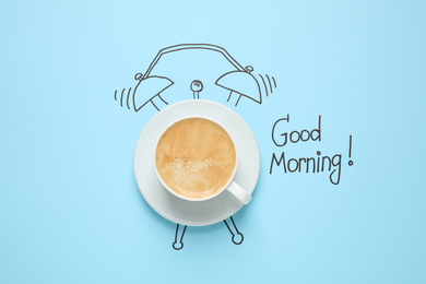 Photo of Composition with Good Morning wish and aromatic coffee on light blue background, top view