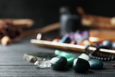 Photo of Many different gemstones on black wooden table