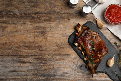 Delicious roasted ribs served on wooden table, flat lay. Space for text