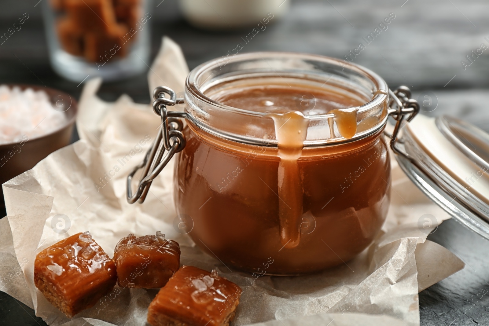 Photo of Jar with tasty caramel sauce on table